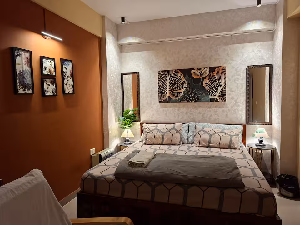 Bedroom 1 with king bed, framed art and warm bedside lamps